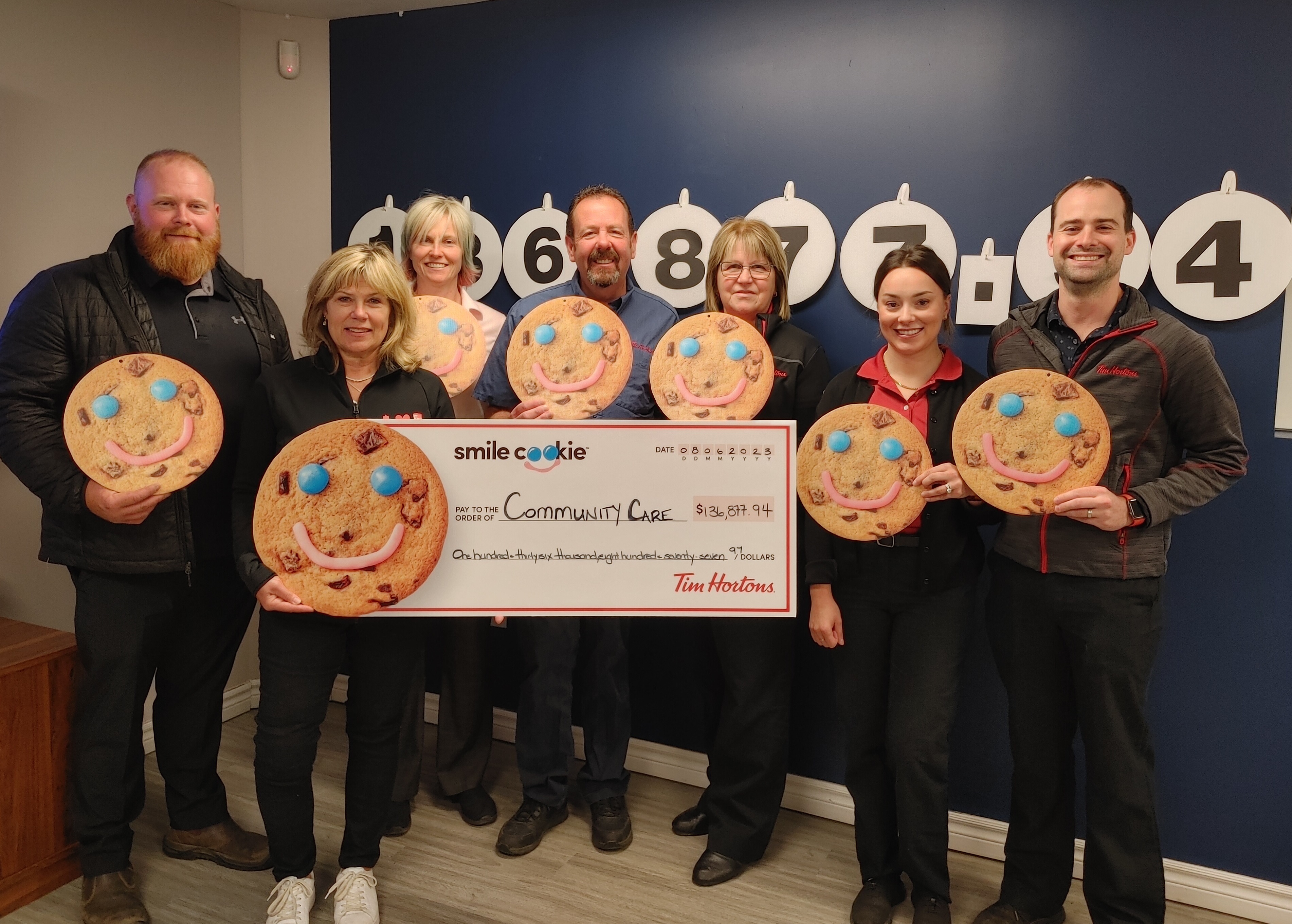 Pictured: Tim Hortons Owners, Ryan Graham, Mary Blair, Erika Howe- Gallagher, Greg Blair, Donna Annett, Jasmine & Stephane Lacoste holding oversized cheque to Community Care Peterborough